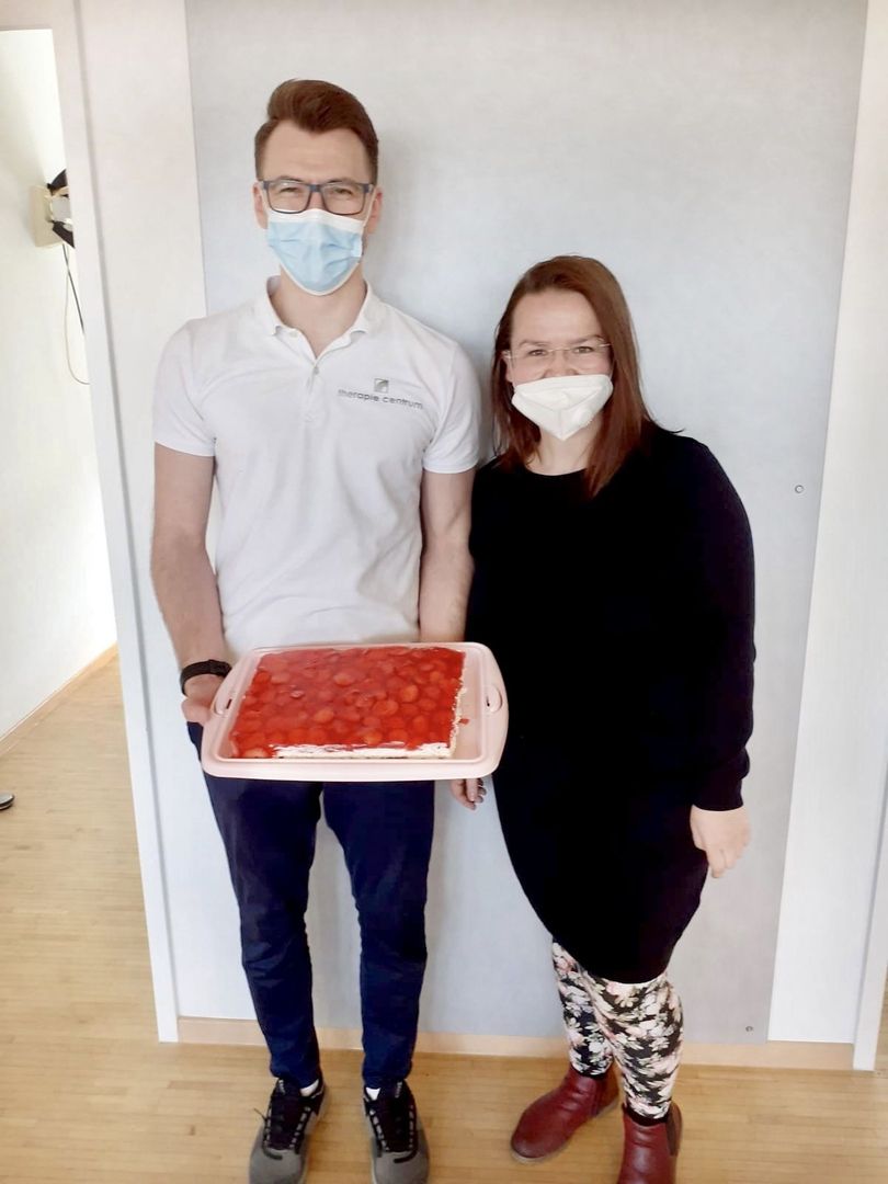 Zwei Mitarbeiter zeigen gebackenen Kuchen